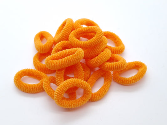 Orangefarbene, weiche Gummibänder mit Knoten